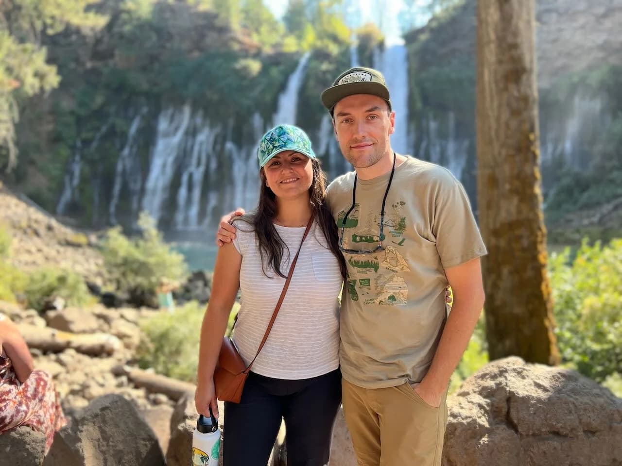Jaylene and Aaron hiking together beside a waterfall